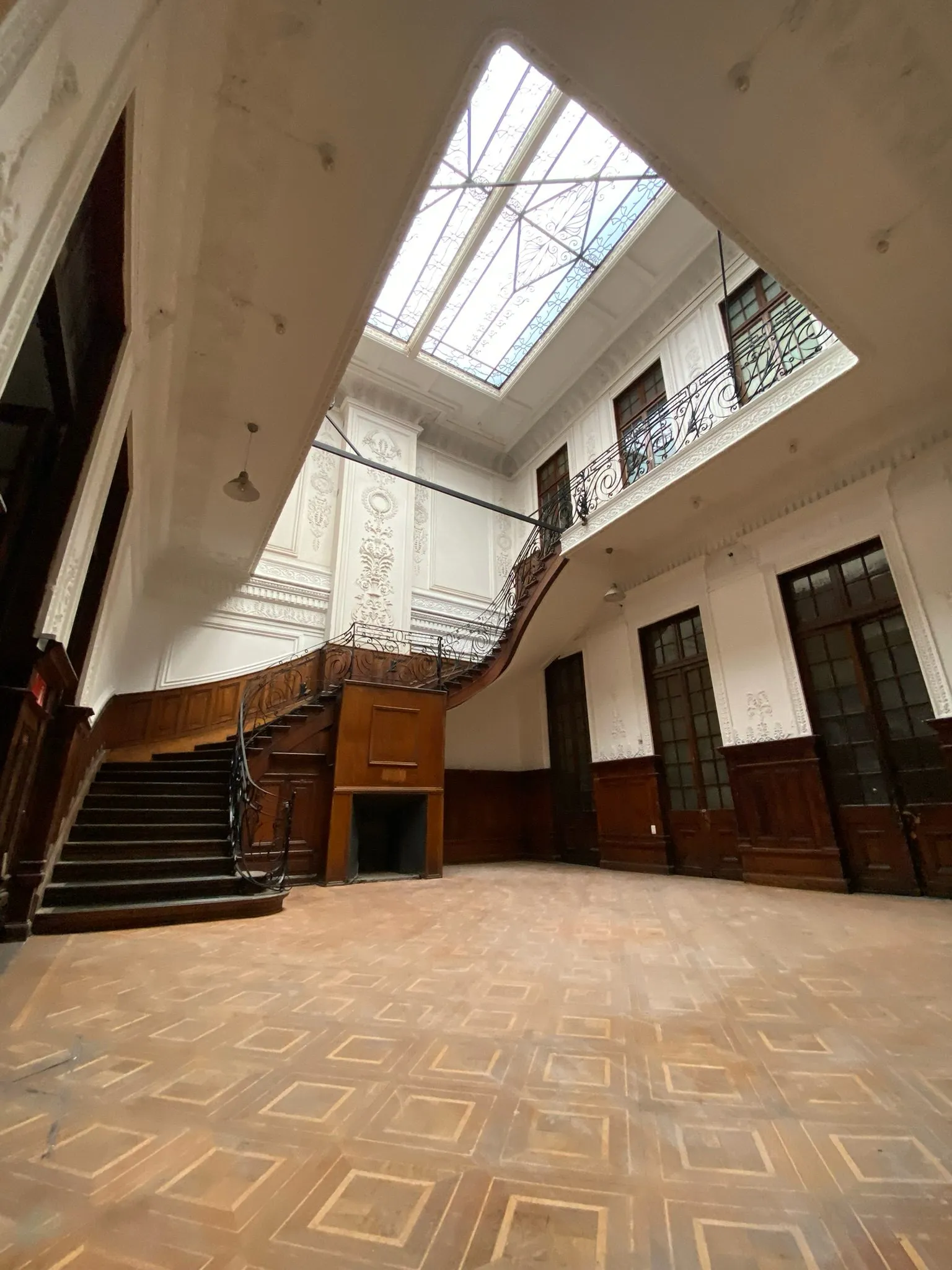Hall restaurado de Casa Huérfanos 1805, con lucarna y escalera de madera